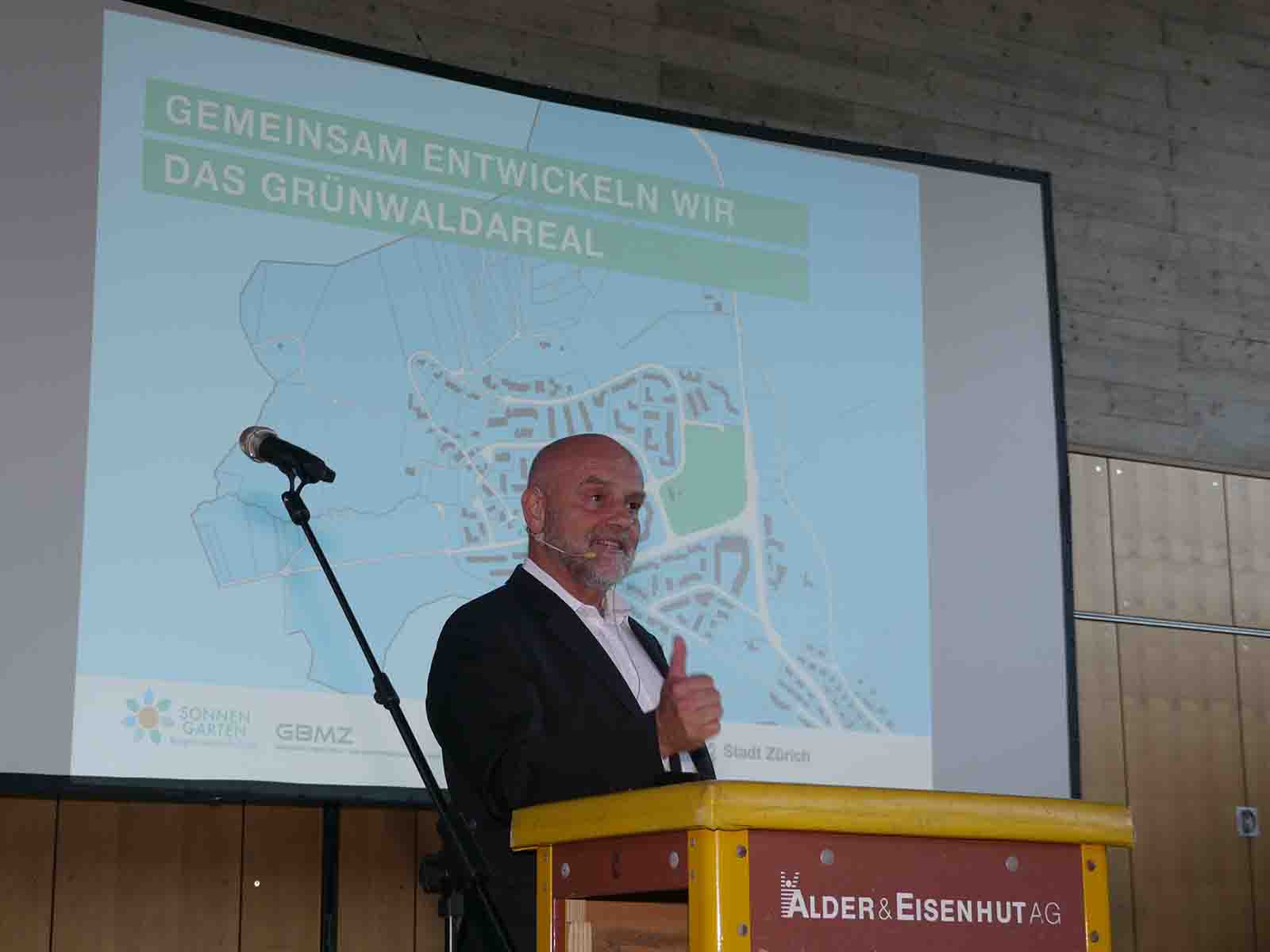 Stadtrat André Odermatt begrüsst zum Ergebnisworkshop «Mitwirkung Grünwaldareal». Ob das «Rednerpult» aus Sprungkästen wohl ein Omen ist?