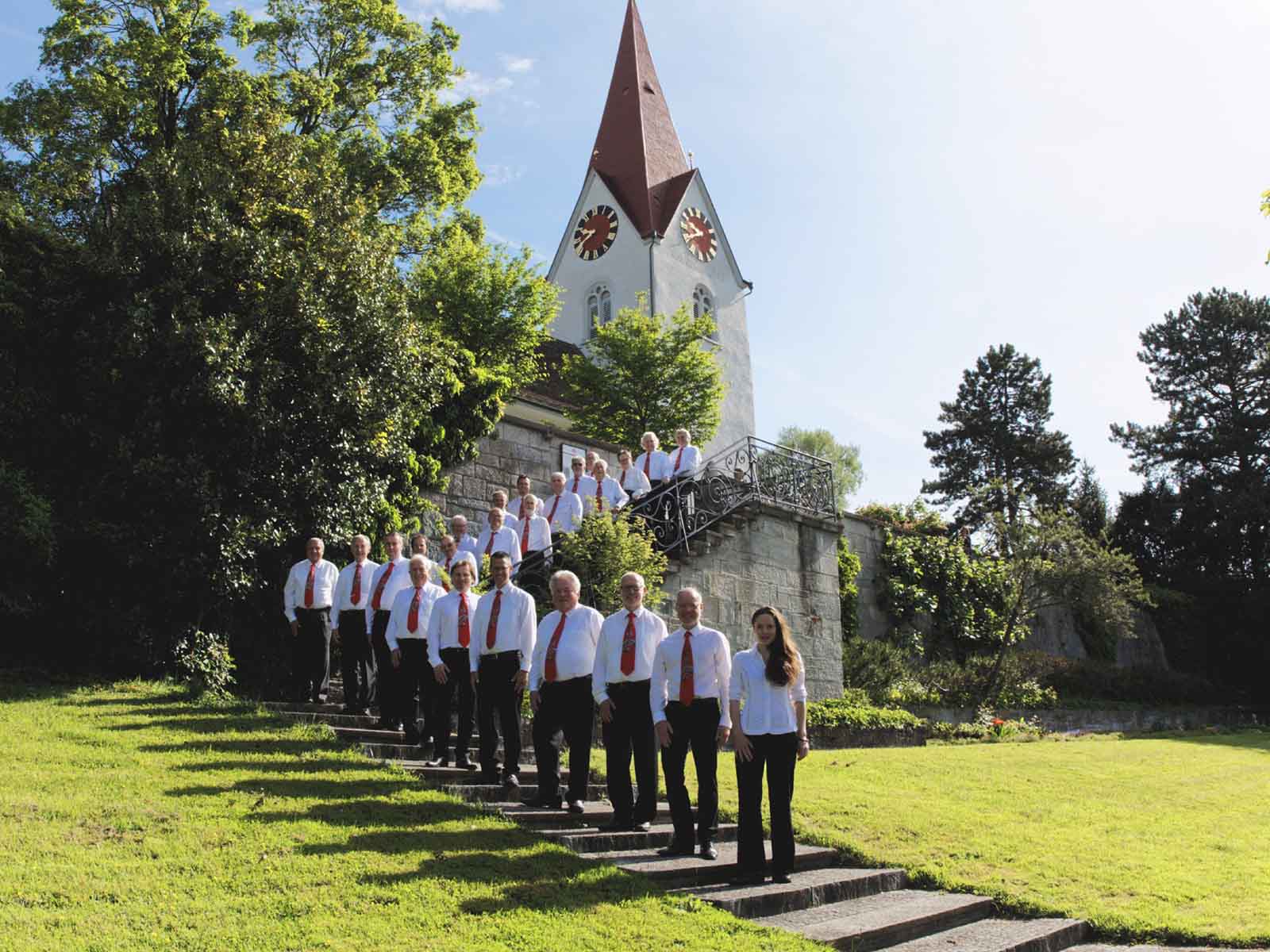 Der stolze Männerchor mit Dirigentin vor der Reformierten Kirche Höngg.