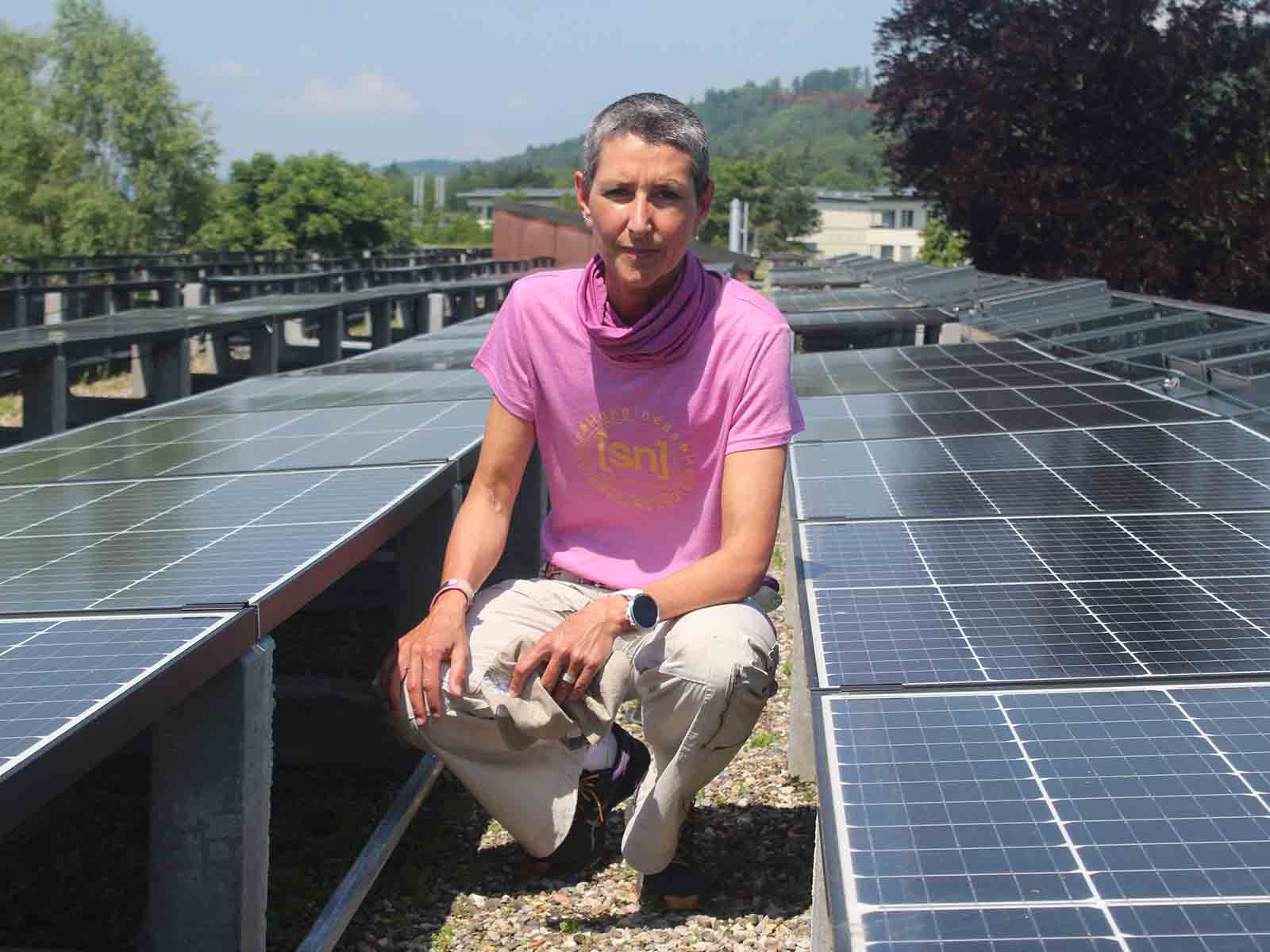 Im Rütihof wird Strom produziert: Iris Hassenpflug, Projektleiterin beim «ewz», inmitten der Solarmodule auf dem Schulhausdach.